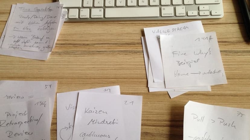 Handwritten reading notes grouped into topic clusters on a desk before being developed into Zettels.