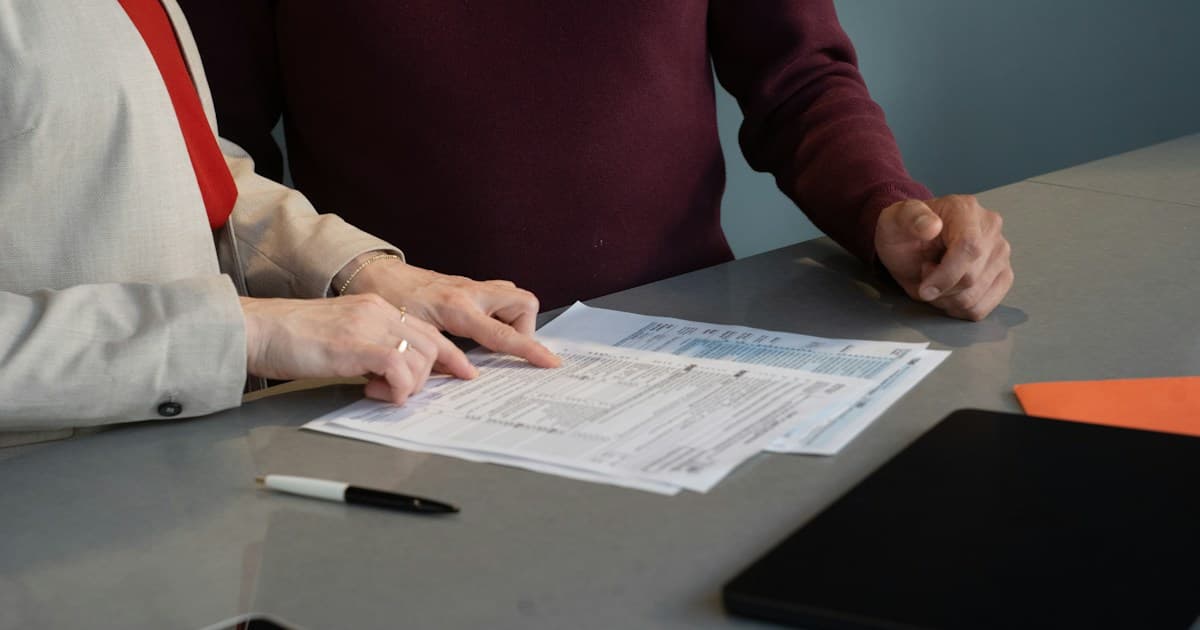 Two professionals review a printed document together.