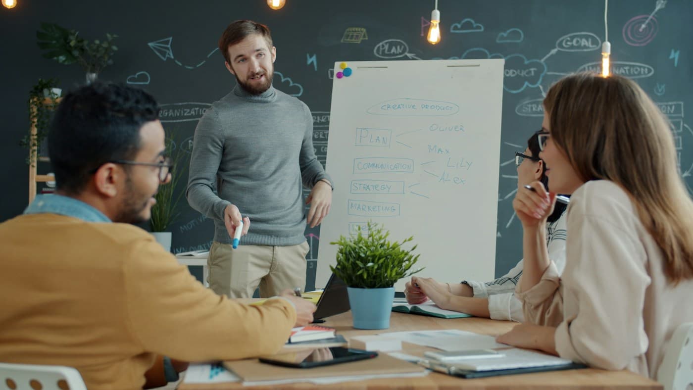 A team reviews a sketched product strategy around a whiteboard.
