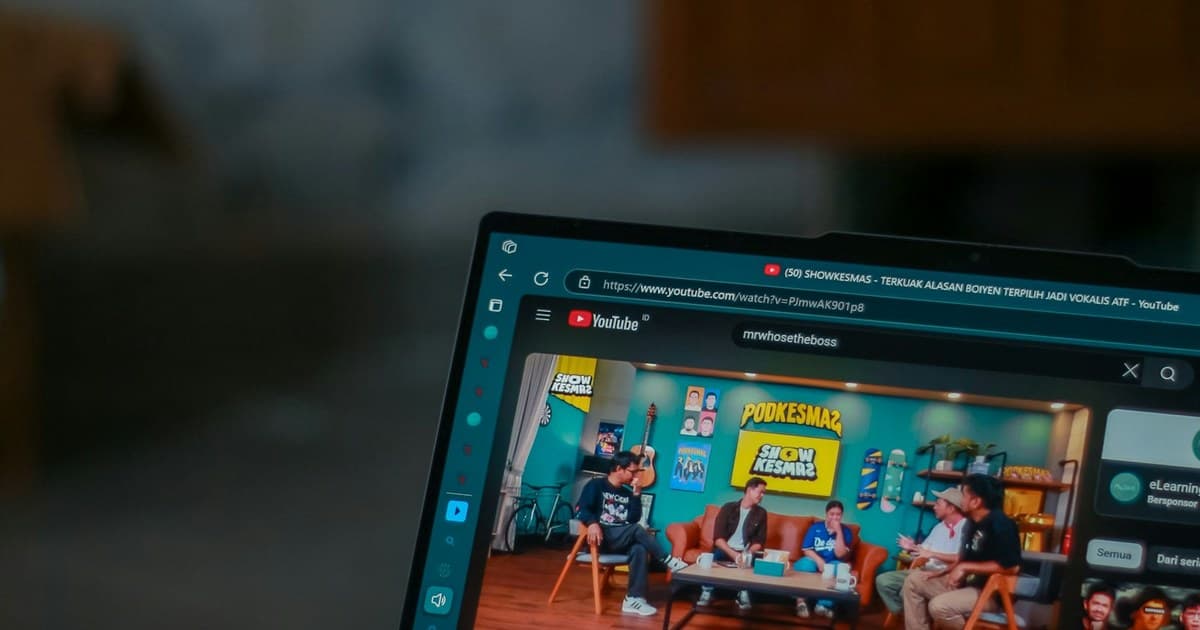 A laptop screen displays a YouTube video page.