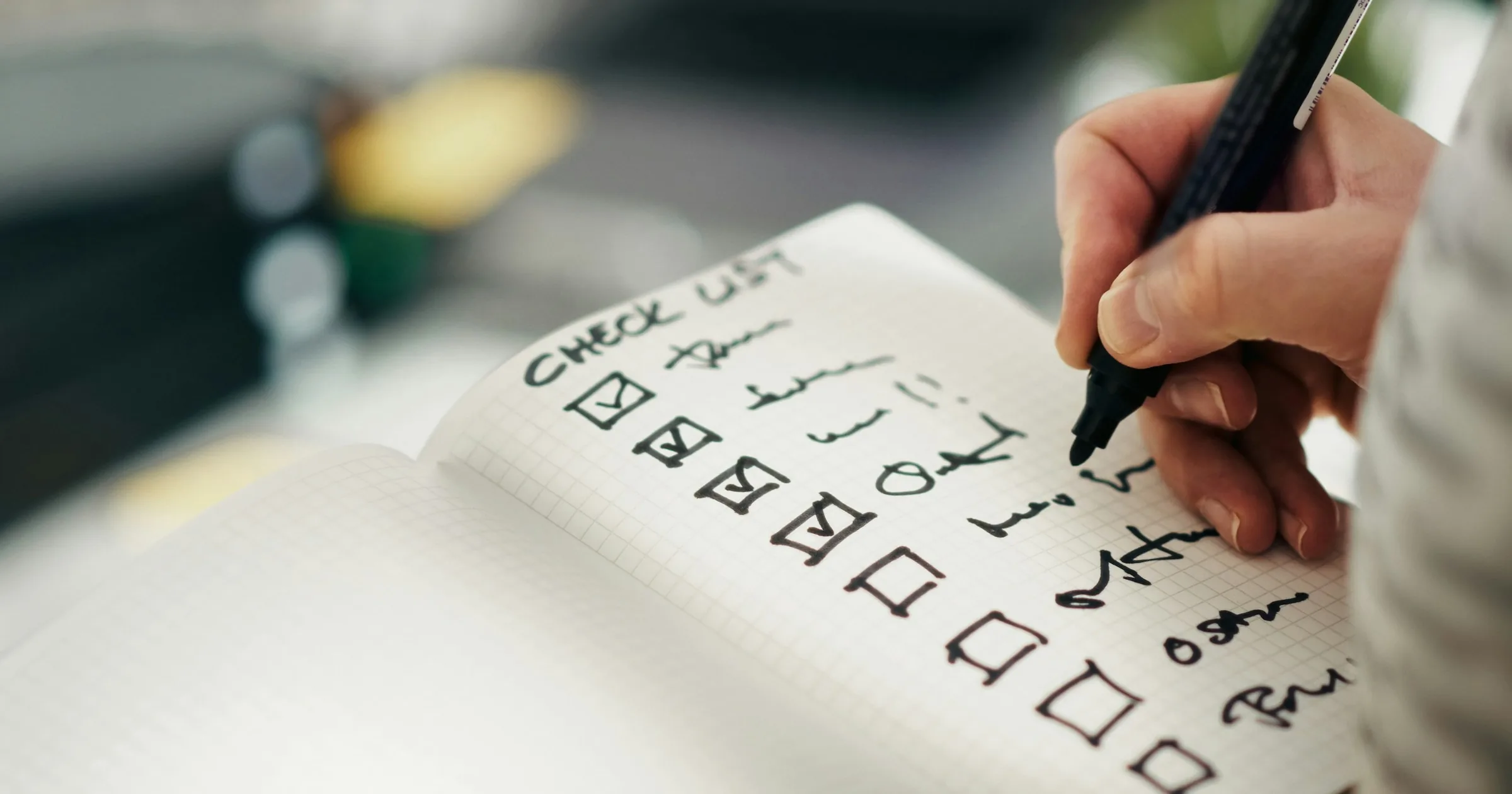 A hand checks items off a handwritten list.
