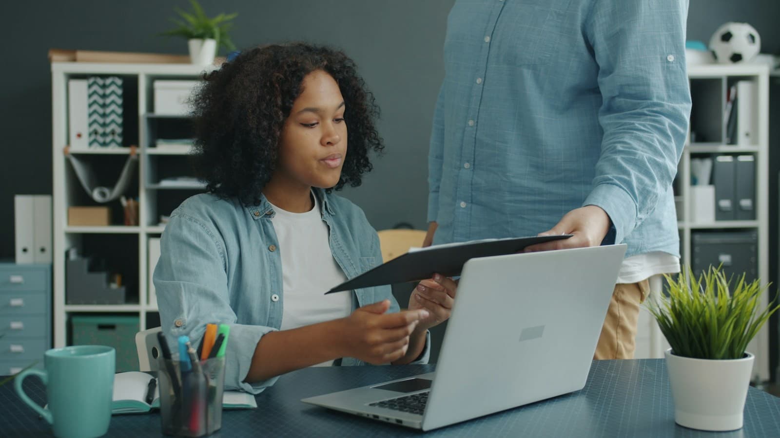 Colleagues review documents together at a desk.