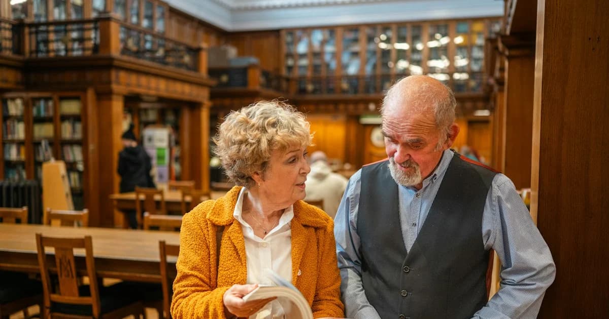 Two people discuss a book in a library.