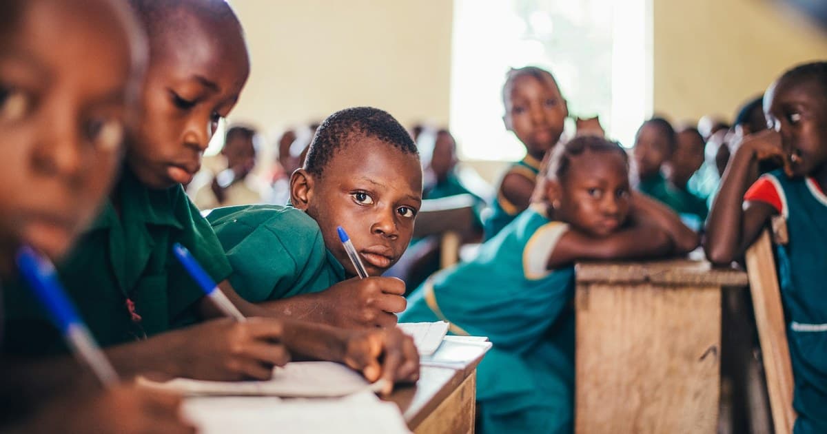 Schoolchildren write in their books in a classroom.
