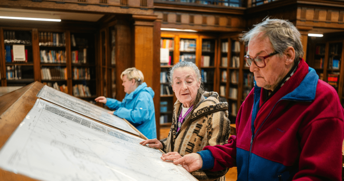 Visitors look at a printed map.