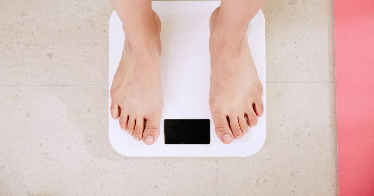 A person stands on an unbranded digital scale.