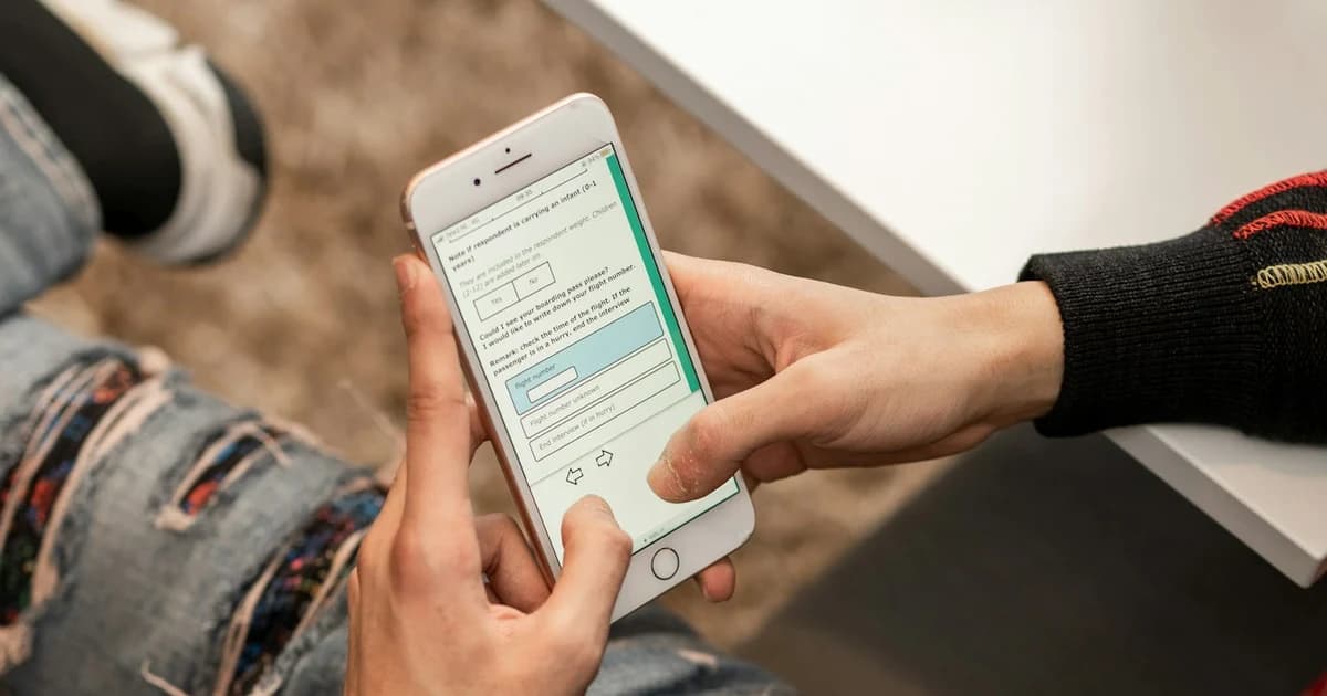 Hands complete a survey questionnaire on a mobile phone.